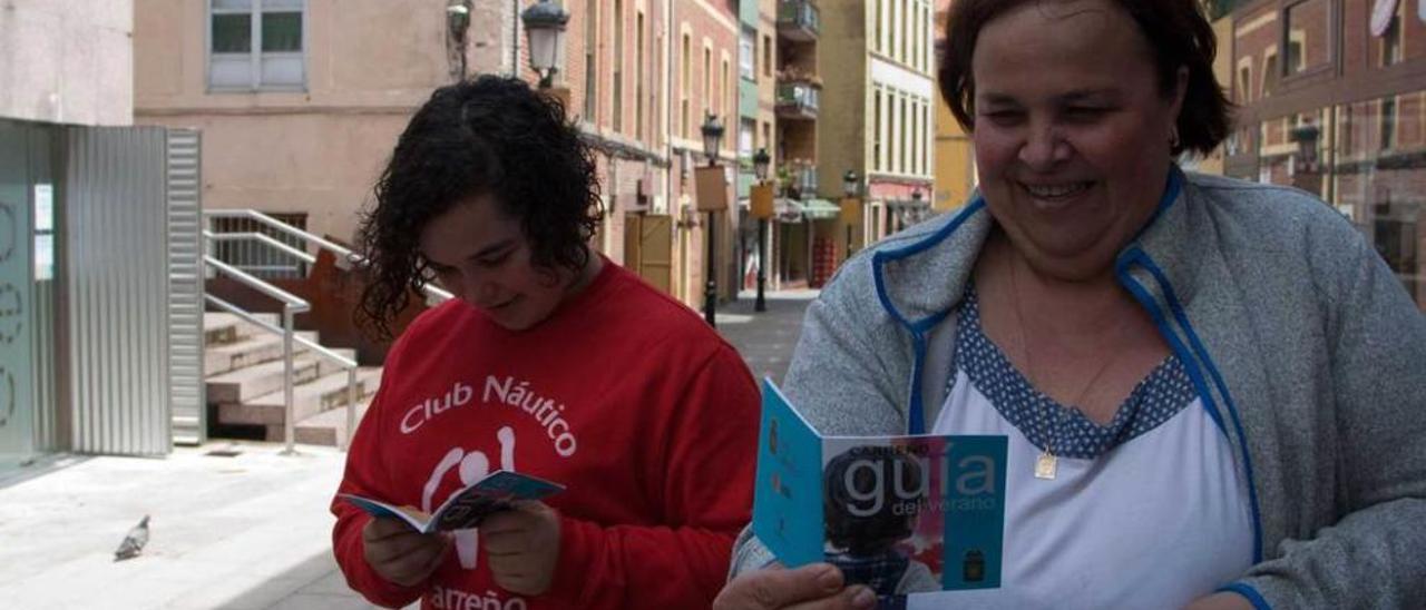 Carmen Sánchez y Conchi Rodríguez, con la guía, junto a la Oficina de Turismo, en la calle Braulio Busto.