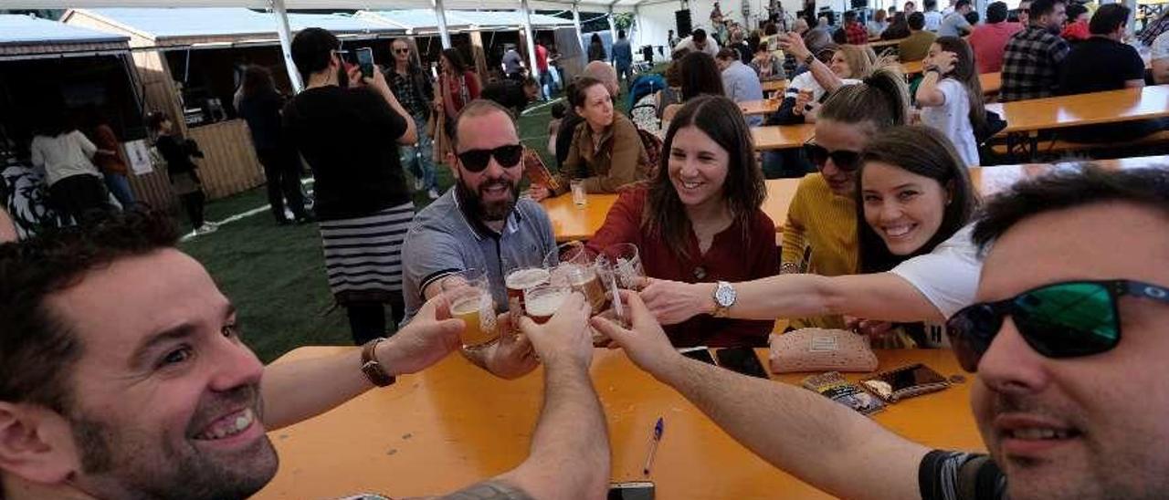 Un grupo de asistentes al festival brinda con cerveza.