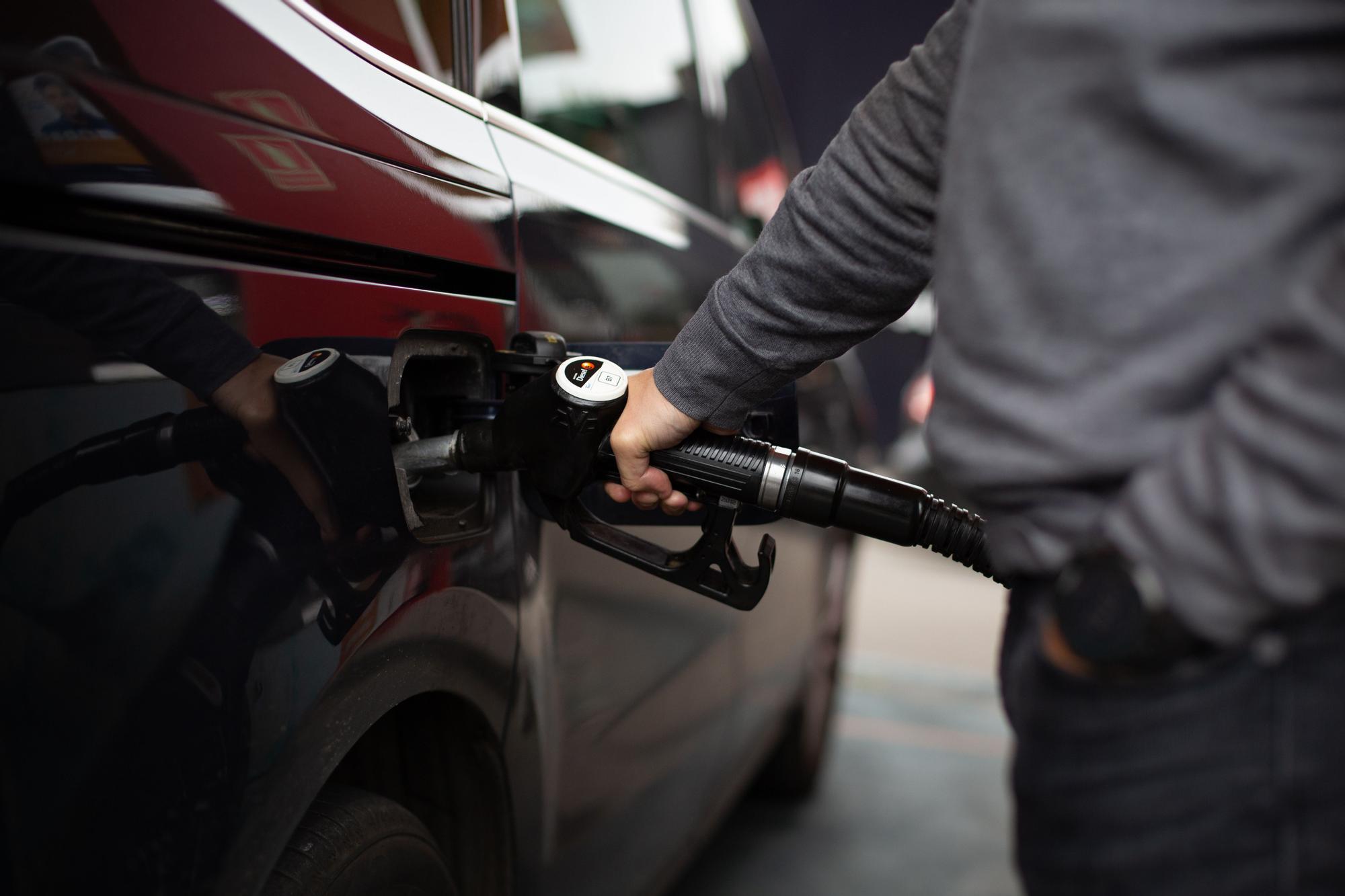 Un hombre repostando en una gasolinera.