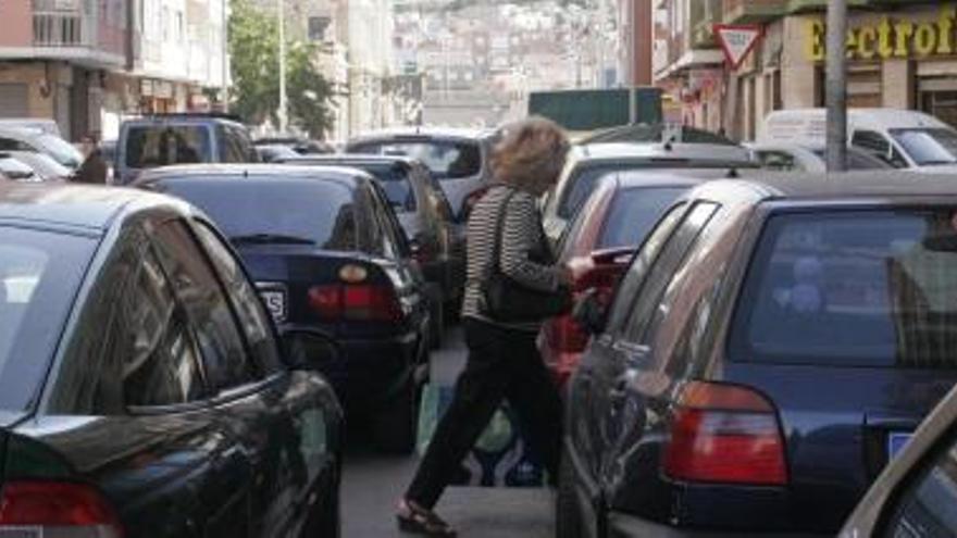 Los coches estacionados en doble fila dificultan la correcta circulación de vehículos por la carretera