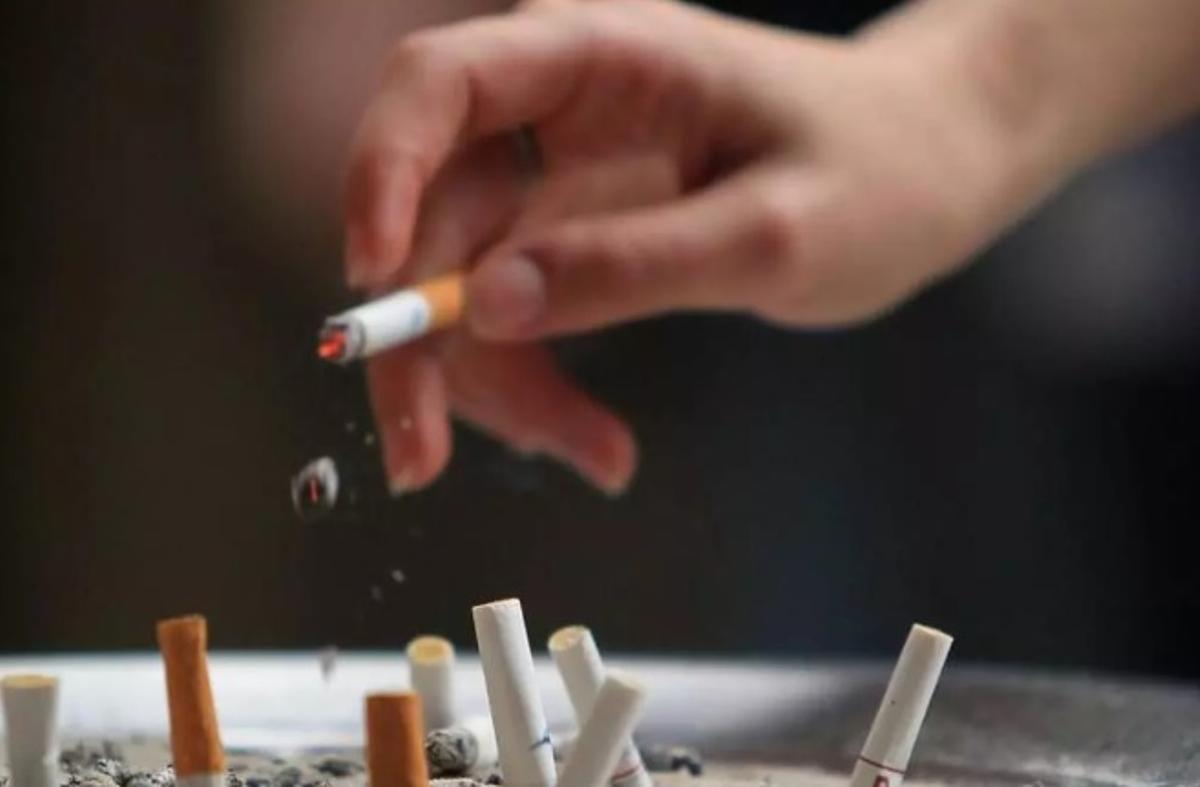 Una persona fuma un cigarro.
