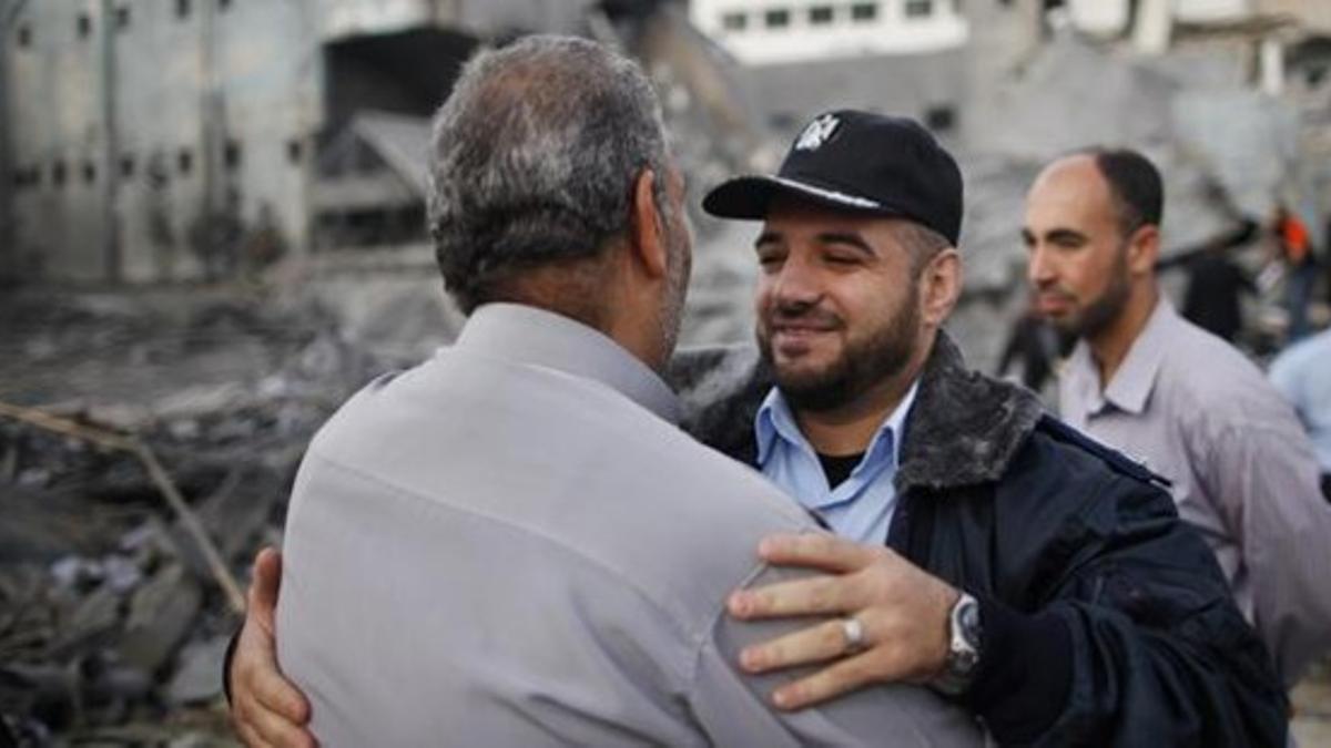 Un policía se abraza a un palestino al regresar a su cuartel destruIdo en Gaza.