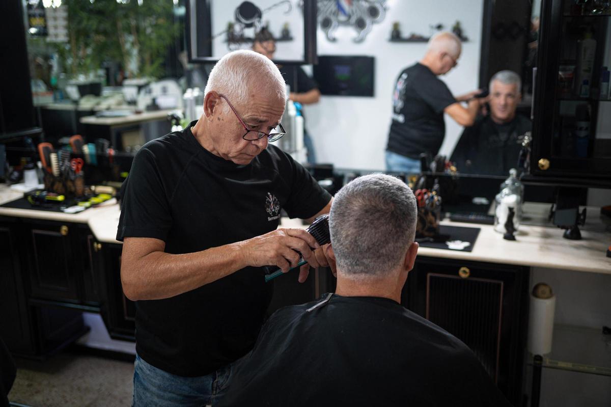 Un peluquero antiende a un cliente.