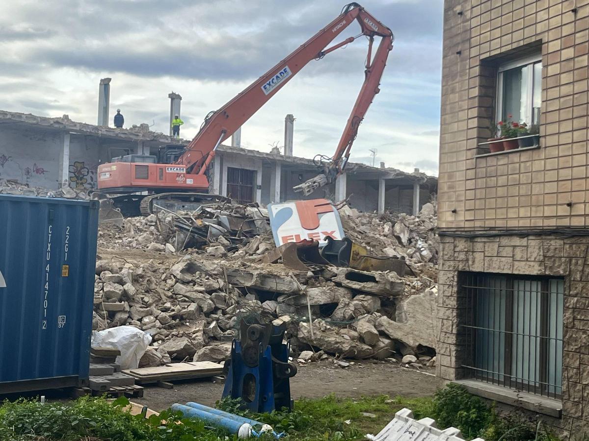 Un cartel de Flex sobre los escombros de la nave en demolición.