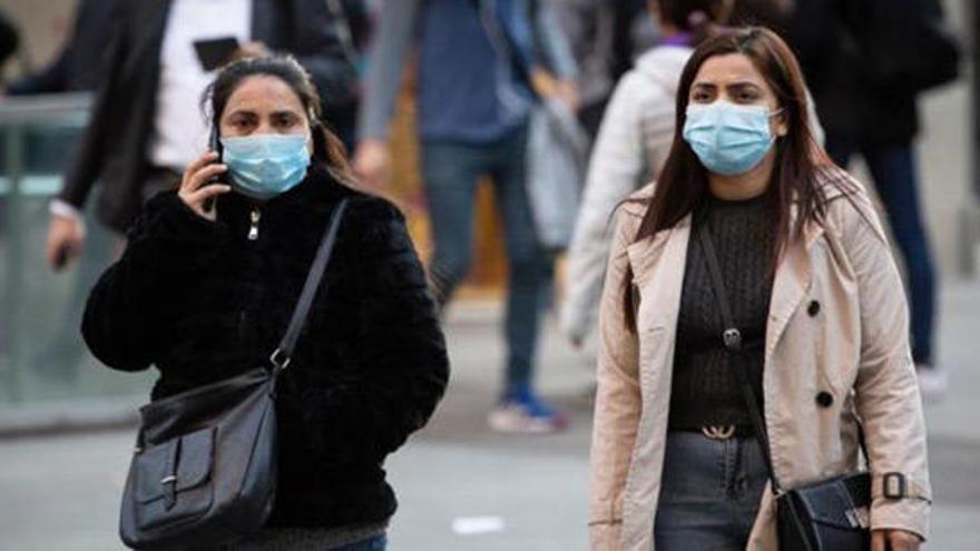 Mujeres caminan con mascarillas por el coronavirus.