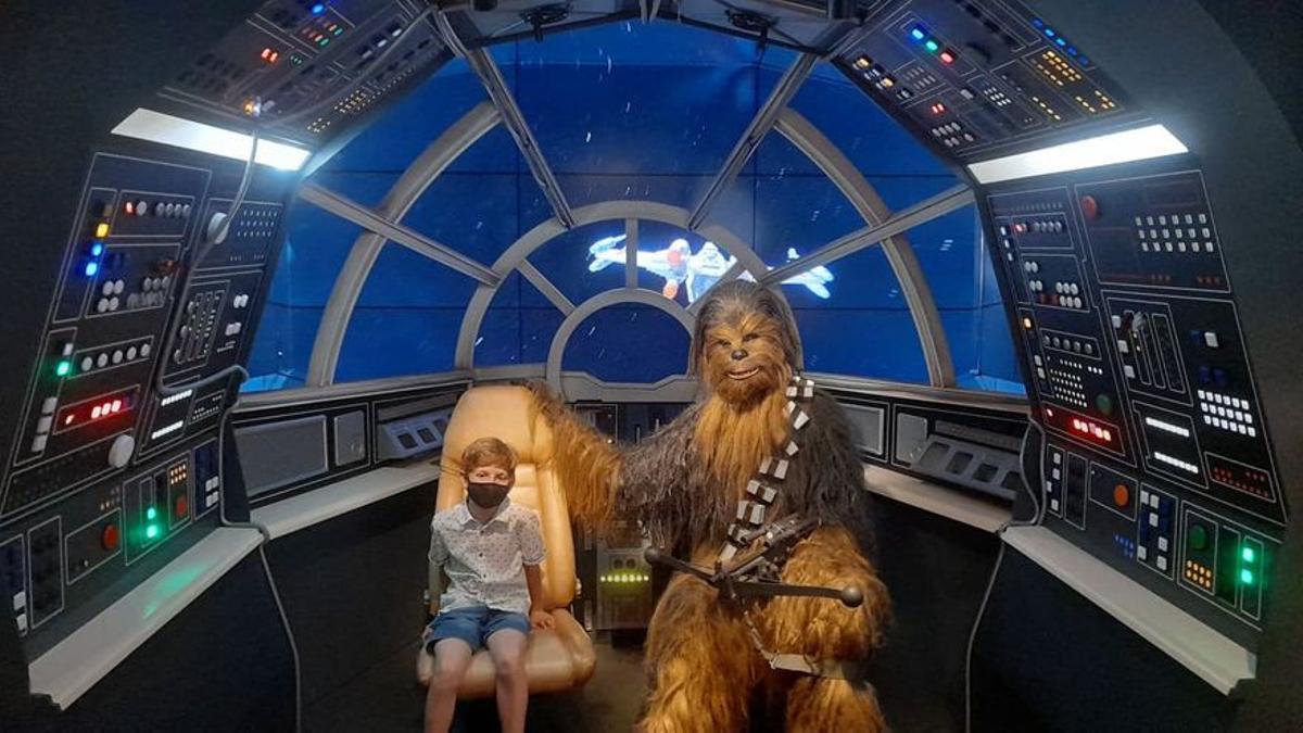 Un niño posa con Chewbacca en la sala de 'Star Wars'.
