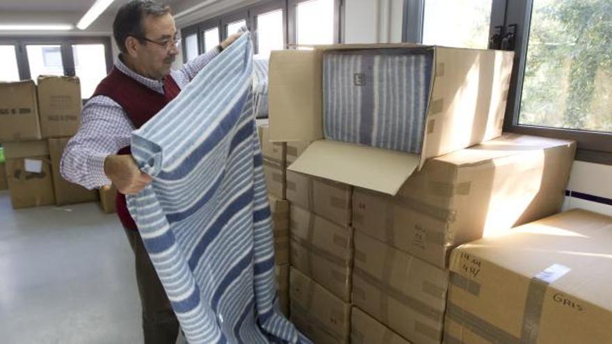 Un responsable de Casa Caridad Valencia muestra una de la mantas, que ya tienen preparadas para repartir cuando llegue el frío.