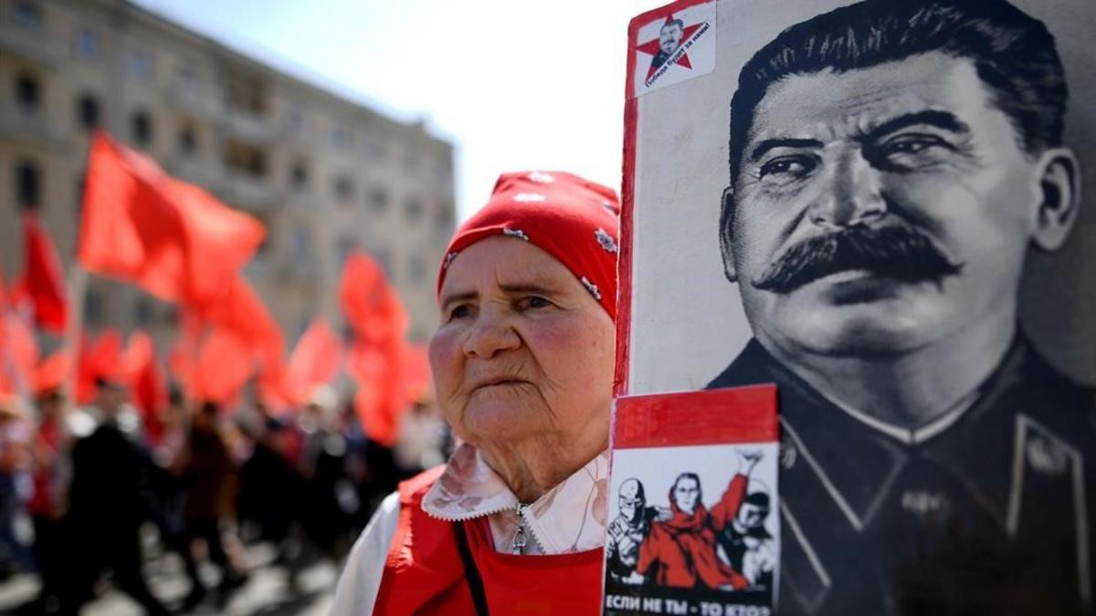 Una mujer del Partido Comunista porta una bandera con el retrato de Stalin en la manifestación del 1 de Mayo del 2017 en Moscú.