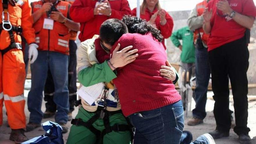 Un minero abraza a su mujer después de ser rescatado.