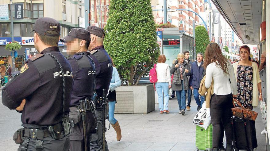 Tres agentes, en primer plano, ayer en la comercial avenida de Maisonnave de Alicante.