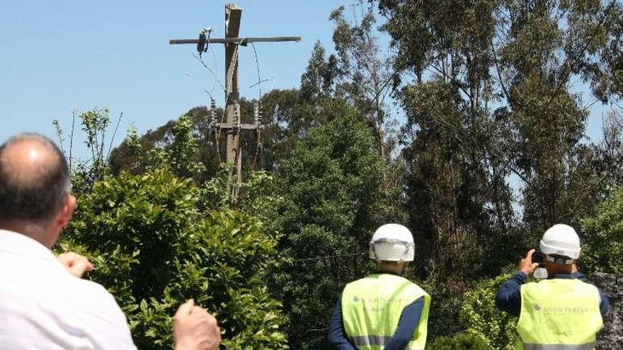 Un grupo de electricistas, ante el poste roto. // Bernabé/V. Espiño