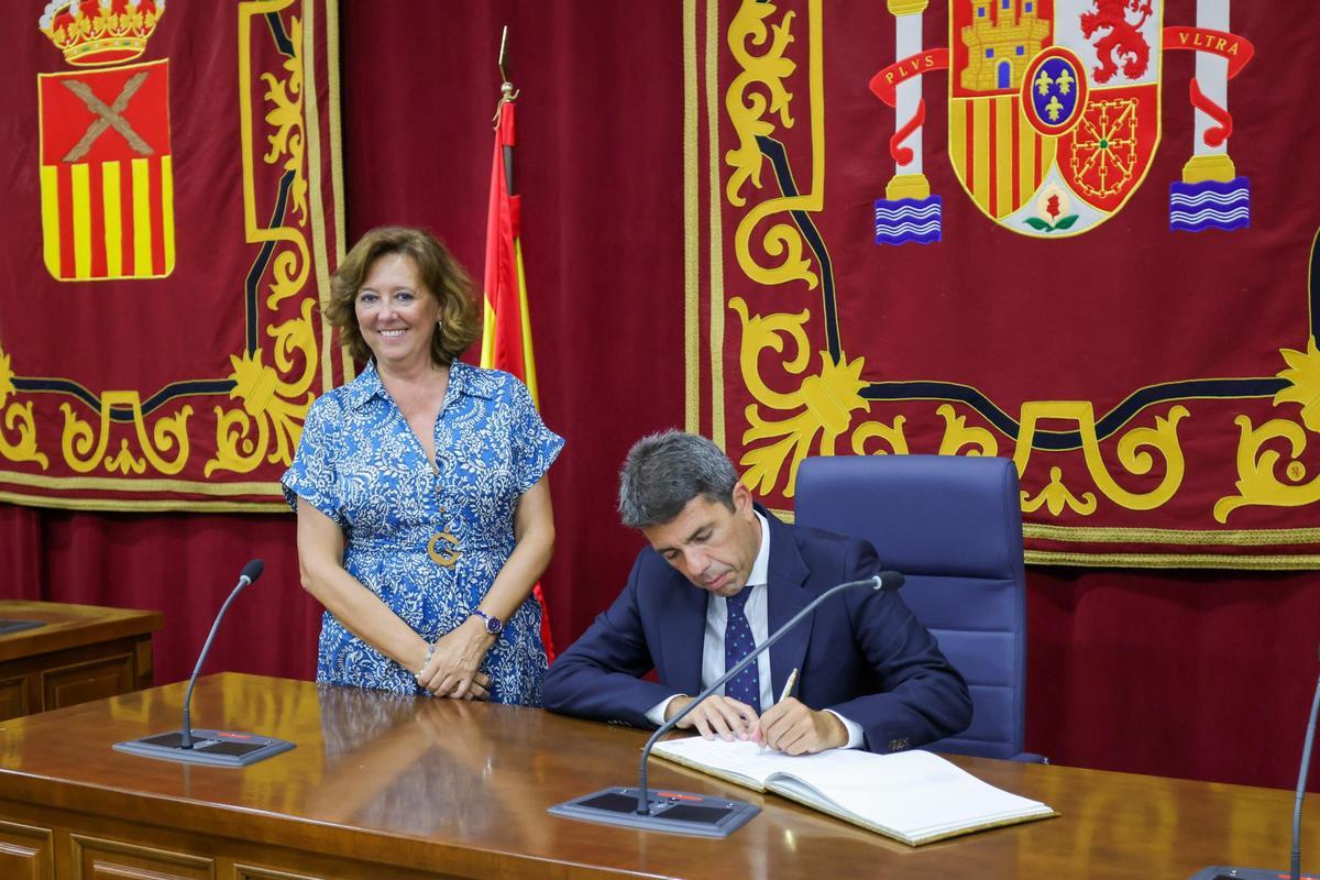 Carlos Mazón firma en el libro de honores del Ayuntamiento de Almoradí ante una sonriente María Gómez