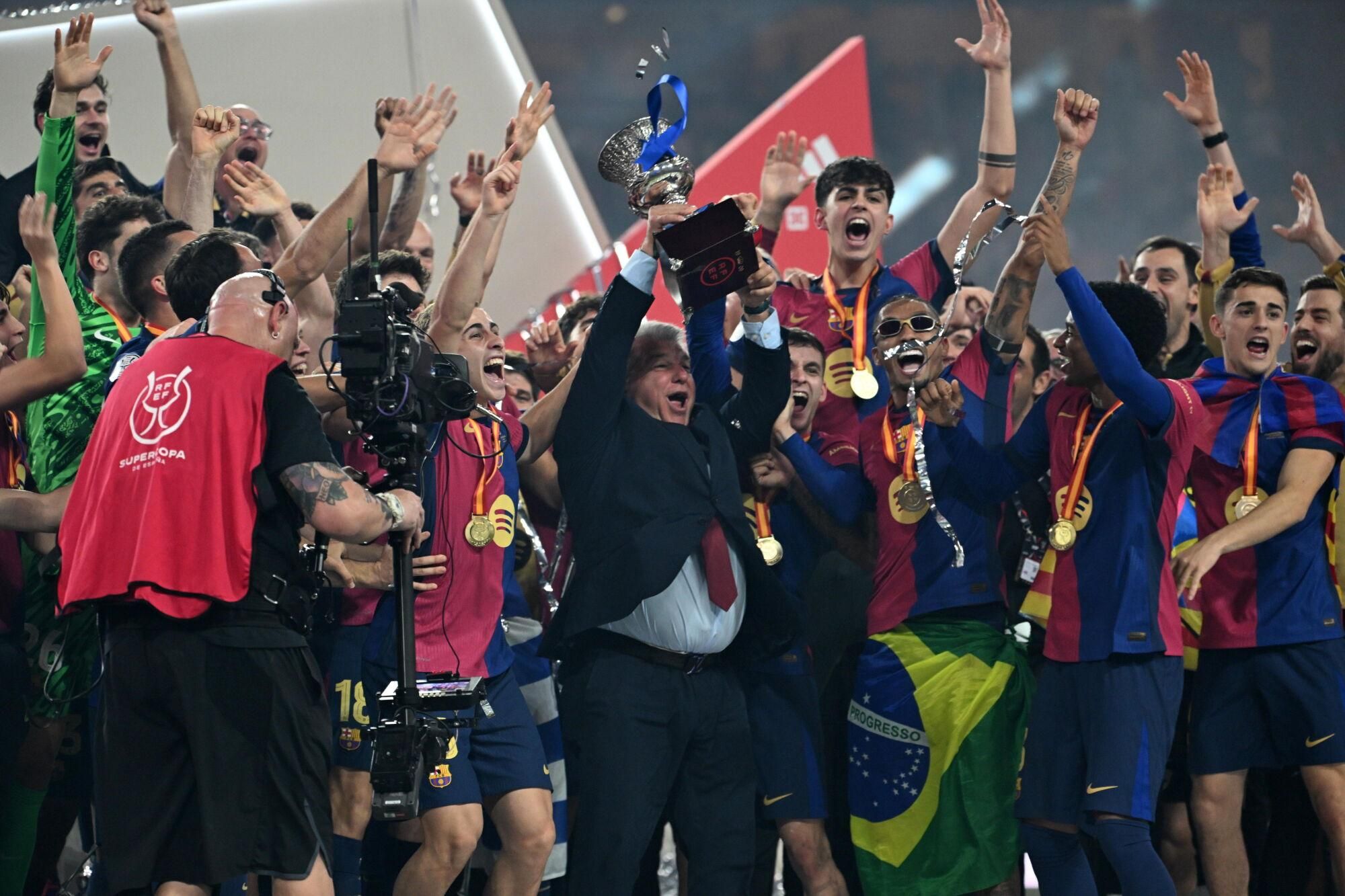 La plantilla y Laporta con el trofeo tras el partido de la final de la Supercopa de España de fútbol entre el Real Madrid y el FC Barcelona, este domingo en Yeda, Arabia Saudí. EFE/EPA/STR. (Barcelona)
