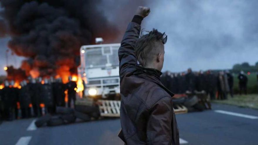 Un manifestante alza el puño ante un grupo de antidisturbios que pretenden romper el bloqueo a una refinería al noreste del país. // Efe