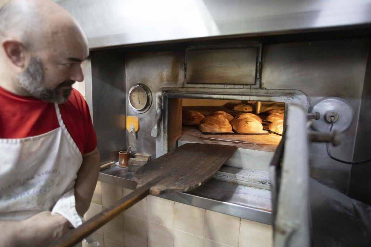 Un panadero introduce monas de pascua en su horno.