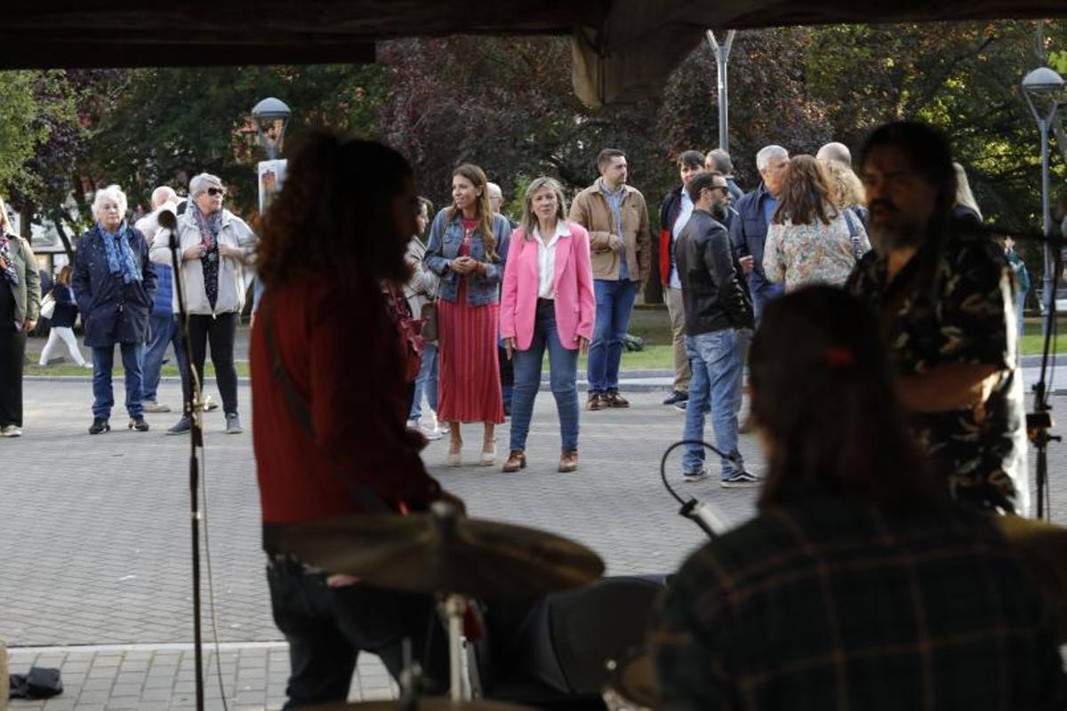 Arriba, Esther Llamazares (PP) y su candidatura, ante «Los Tríceps». A la izquierda, Arancha Martínez, con intregrantes de su lista y simpatizantes de Voz, en la Feria del Queso y el Vino. | Ricardo Solís