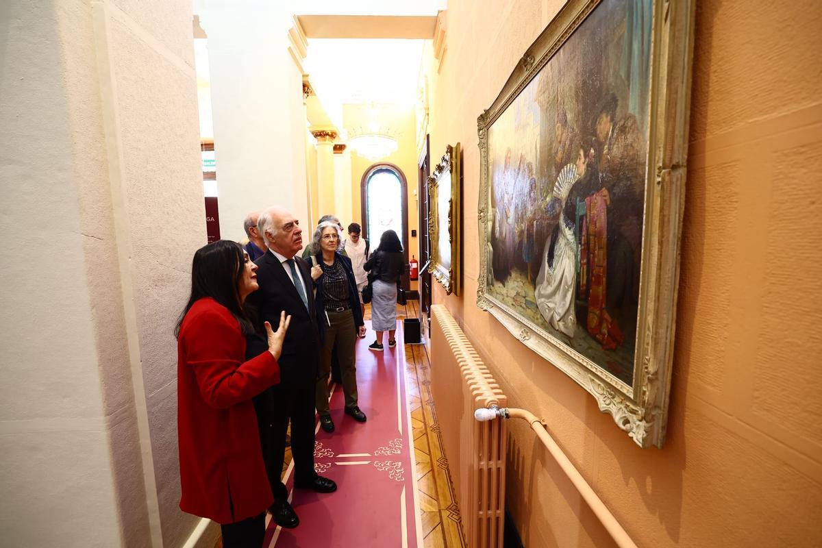 Marisa Oropesa y José Luis Rodrigo, director general de Fundación Ibercaja, observan uno de los cuadros expuestos en el Palacio de Larrinaga