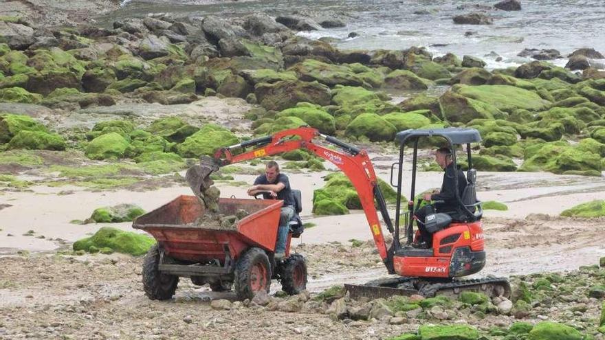 Maquinaria trabajando en la retirada de las piedras del centro de la playa.