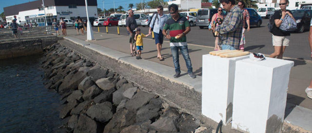 Ashok Bhagnani (derecha) y Gangadhar Tejwani en el puerto de Playa Blanca dándoles pan a los peces.