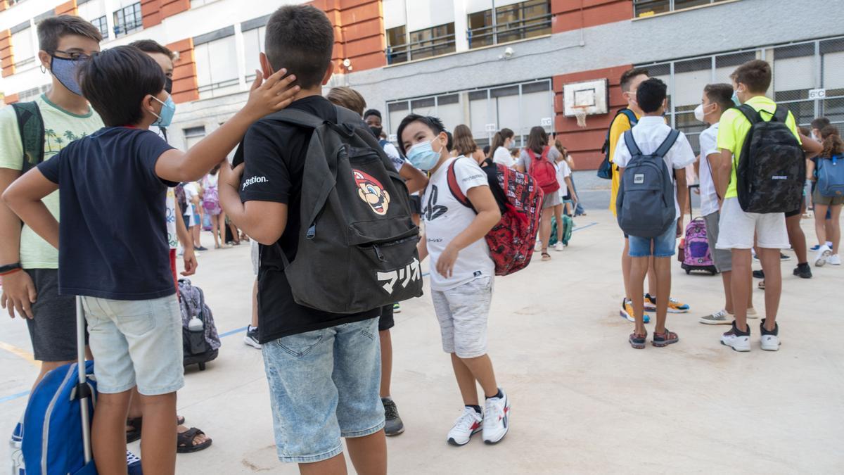 Alumnos con sus mochilas a la entrada de un colegio de Cartagena.