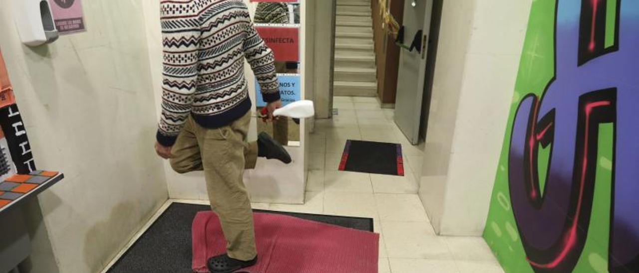 Un usuario del centro de personas sin hogar desinfectando su calzado en las peores semanas de la pandemia. | M. Villamuza