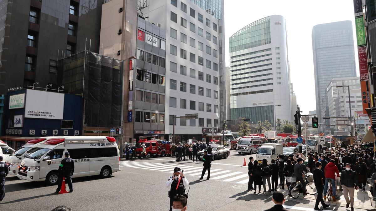 Curiosos y efectivos de rescate frente al edificio incendiado en Japón.