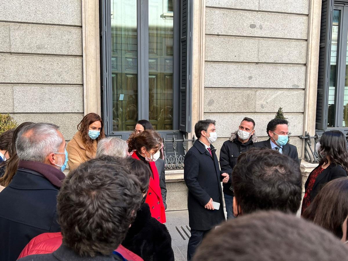 La presidenta de la Comunidad de Madrid, Isabel Díaz Ayuso, (con abrigo rojo) a su llegada al Congreso.