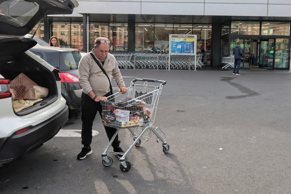 Un hombre llena con su compra su maletero en Castelló.