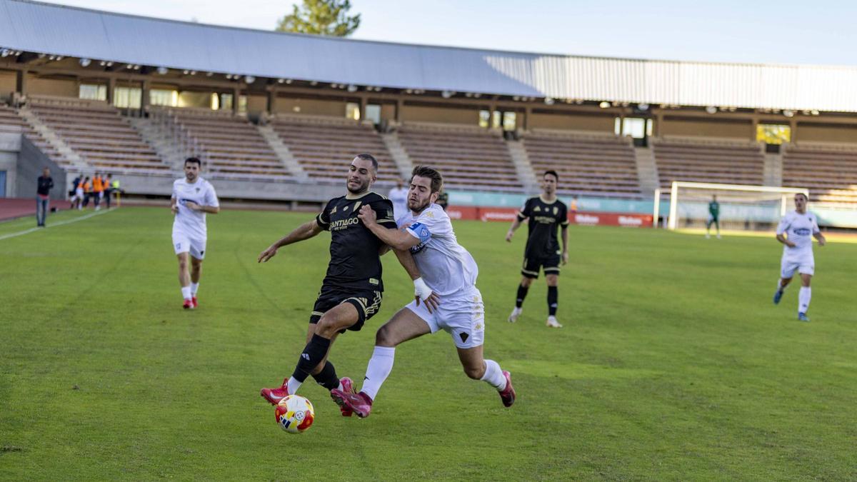 Jorge Maceira pugna con un defensor rival.