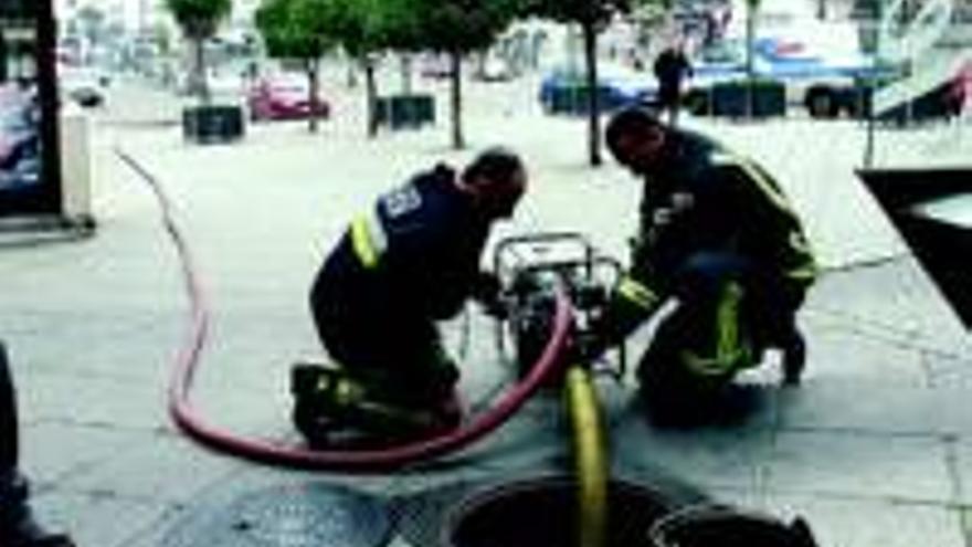 Los bomberos vacían de agua un transformador eléctrico inundado bajo tierra en la plaza Mayor