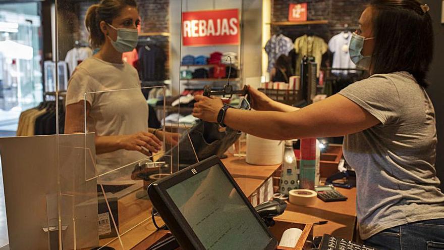 Varias mujeres caminan por Santa Clara, frente a un comercio, con bolsas. | Emilio Fraile