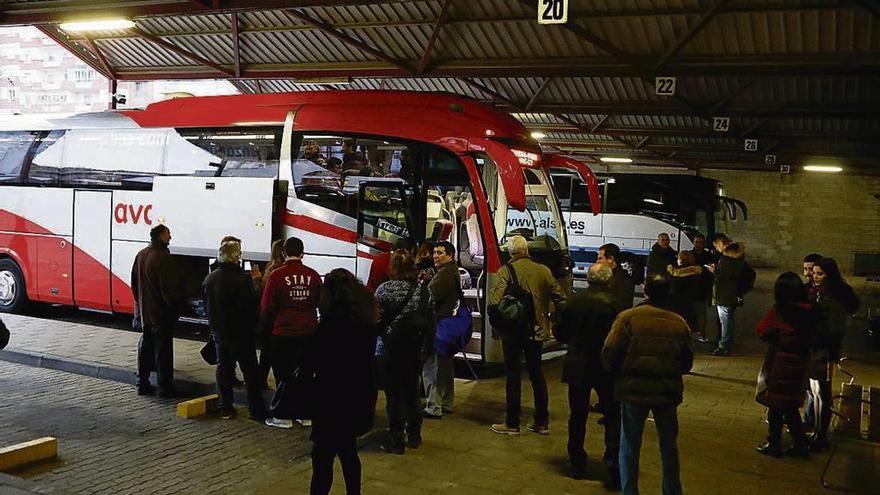 Varias personas se suben al bus con destino Madrid.