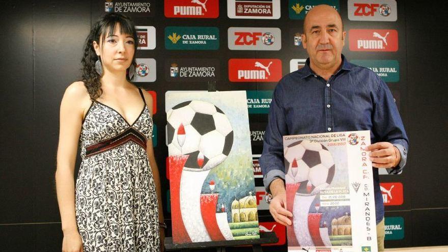 Carmen Ratón y Segismundo Ferrero posan con el cuadro y el cartel del primer partido