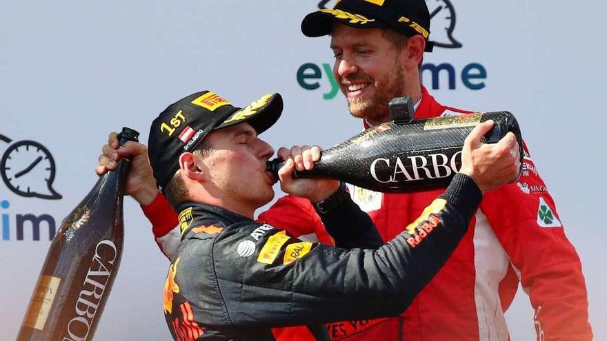 Verstappen bebe champán en el podio acompañado por Vettel, que fue tercero. // Reuters