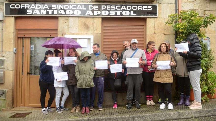 Un grupo de mariscadoras se concentró ayer frente a la cofradía de Carril para protestar por el impago de la semilla de japónica. // Noé Parga