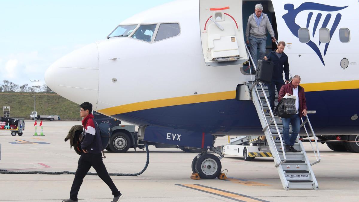 Diversos passatgers baixen d'un avió de Ryanair procedent de Londres a la pista de l'aeroport de Girona