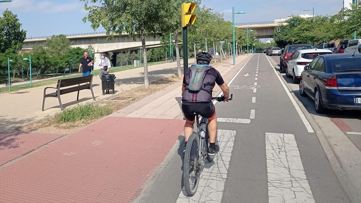 Un ciclista se dirige al puente de Las Fuentes desde el azud del Ebro, por la margen izquierda