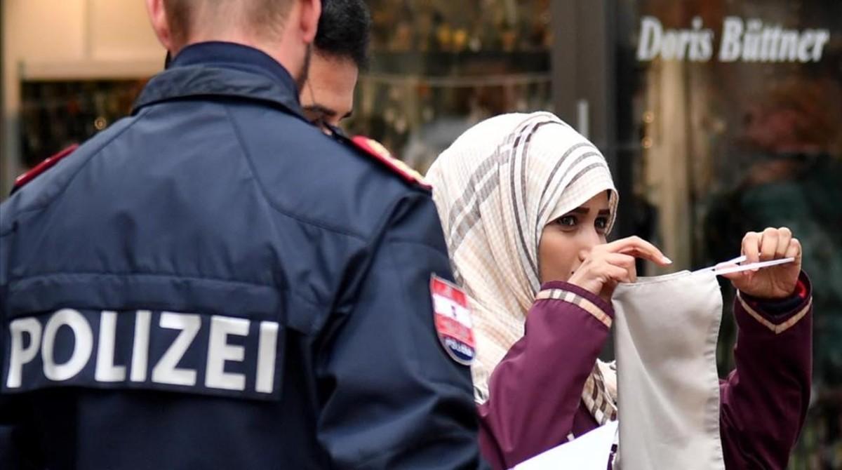 Un policía ordena a una mujer musulmana que se retire el velo en Austria, en octubre del 2017. Un policía ordena a una mujer musulmana que se retire el velo en Austria, en octubre del 2017.