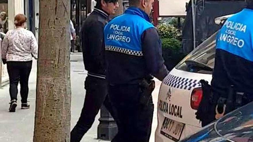 A. G. M. sale del Juzgado de Langreo escoltado por dos agentes de la Policía Local.