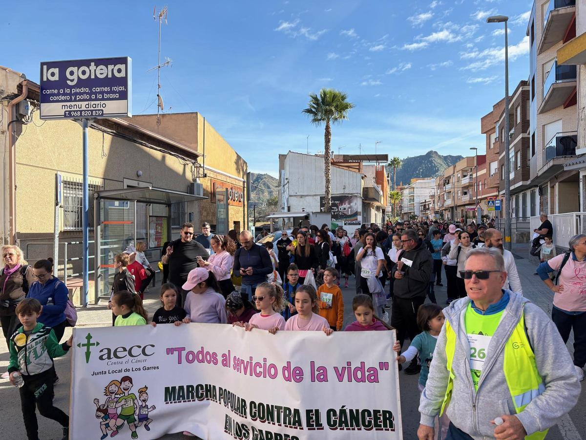 Un grupo de niñas sujetan una pancarta durante la marcha contra el cáncer.
