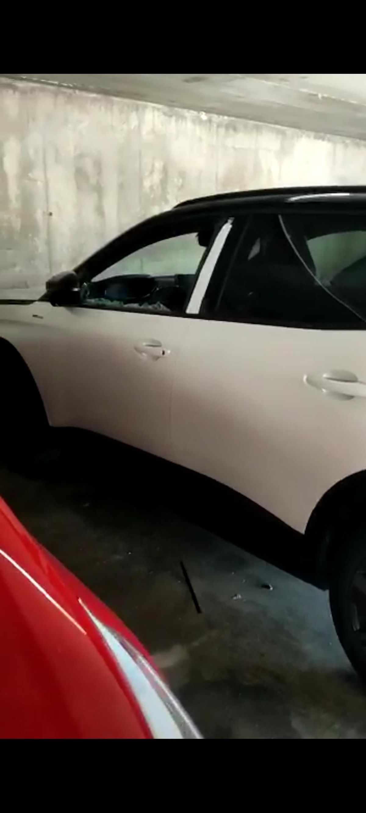 Coche con la ventana rota en el parking del puente Trujillo de Plasencia.