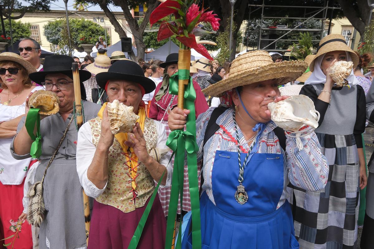 Un grupo de mujeres recibe a la imagen religiosa haciendo sonar sus bucios