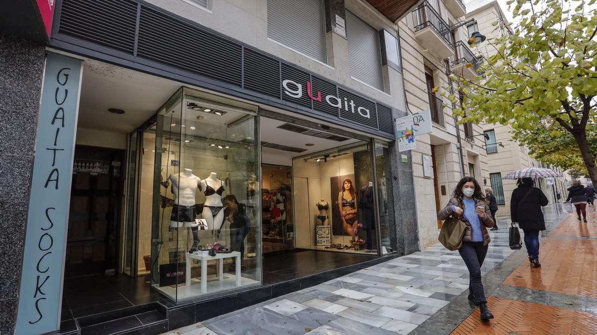 Una mujer sale de un comercio en el centro de Alcoy.