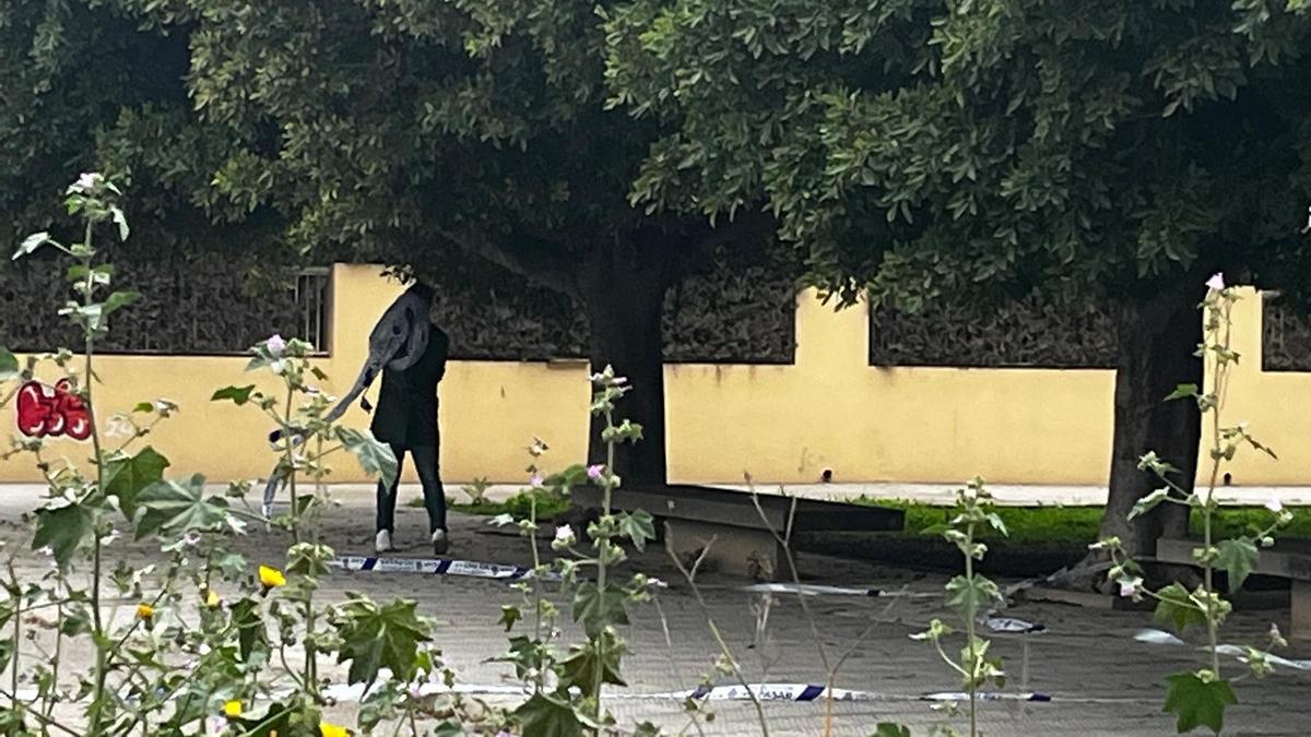 Un agente, recogiendo la cinta policial con la que se acordonó la zona.