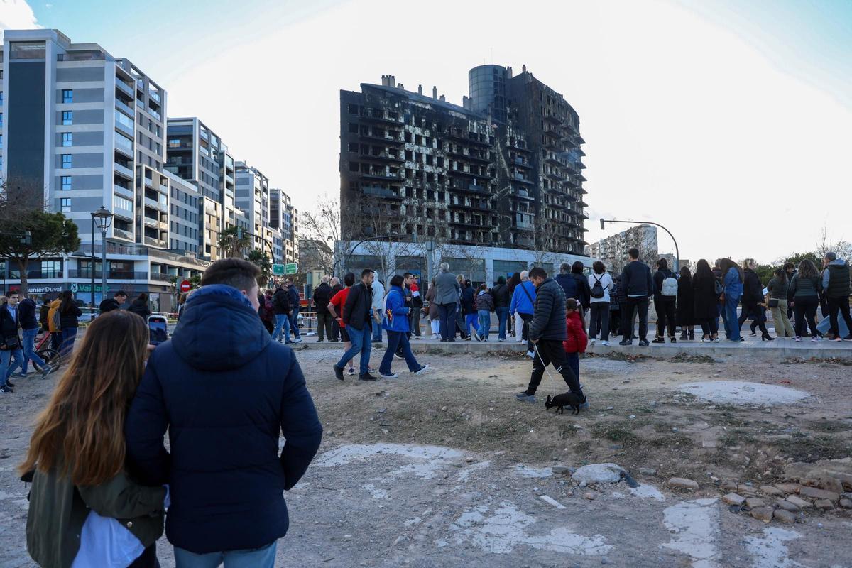 Decenas de curiosos van a ver el edificio quemado en Campanar.