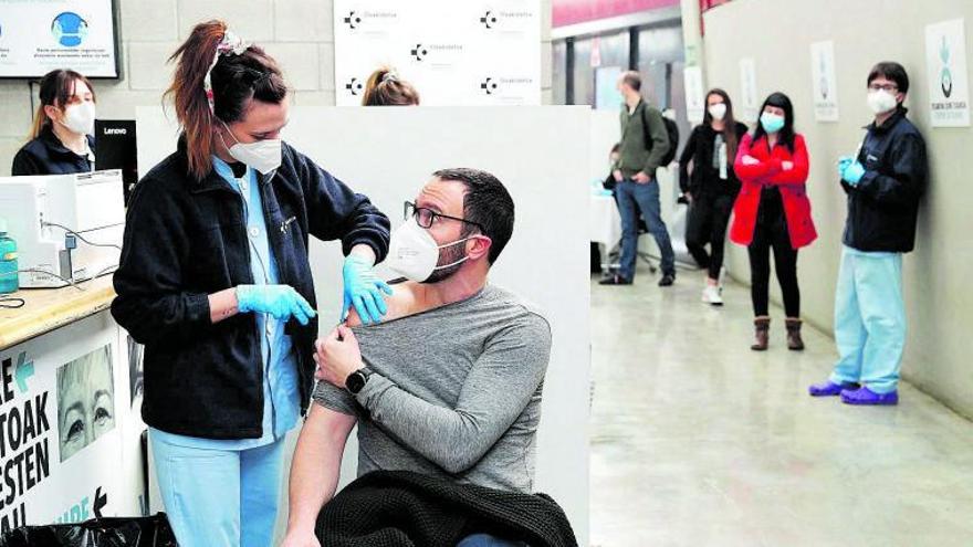 Varios jóvenes participan ayer en el inicio de la vacunación masiva en el recinto de Illunbe, en San Sebastián. | EFE/JUAN HERRERO