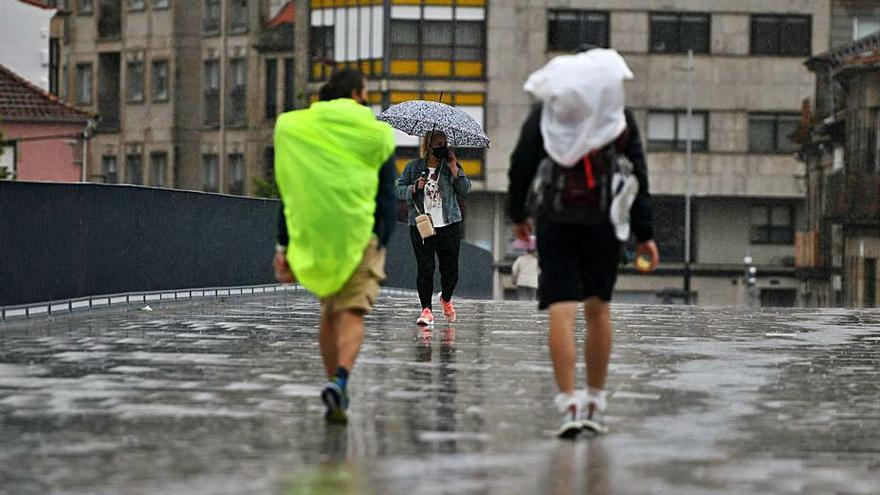 Paraguas y chubasqueros regresaron ayer a las calles.   | // G. SANTOS