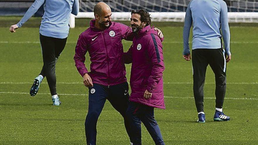 Guardiola bromea con el preparador físico del City, Lorenzo Buenaventura, en el entrenamiento de ayer.