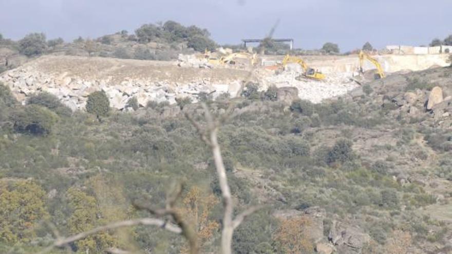 Aspecto que presenta la escombrera de la cantera de Fornillos de Fermoselle. Centro, una máquina tritura el material. A la derecha, la tierra es apilada para la restauración vegetal de la zona.