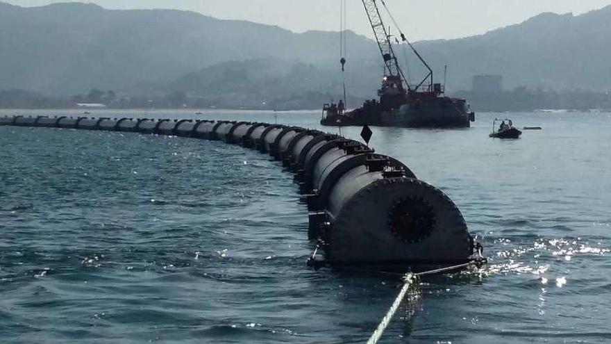 Un momento del fondeo del último tramo del emisario, ayer, a 500 metros de la playa de Samil .  // Acuaes